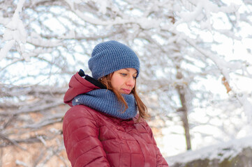 Winter portrait of a girl. Girl in warm clothes. Portrait of a woman in a winter park.