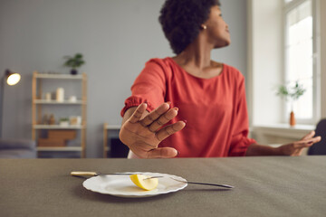 Woman on dieting for good health concept. African american young woman refuse eating. Hand push out...
