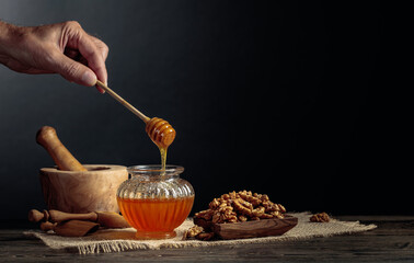 Honey and walnuts on a old wooden table.