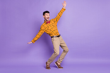 Fototapeta na wymiar Full body photo of young excited carefree man happy positives mile have fun look empty space isolated over purple color background