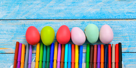 Colorful eggs and markers painted by children before Easter.