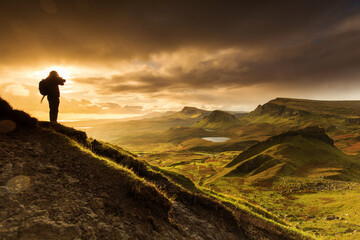 Fototapeta premium Scenic view of Quiraing mountains in Isle of Skye, Scottish highlands, United Kingdom. Sunrise time with colourful an rayini clouds in background.