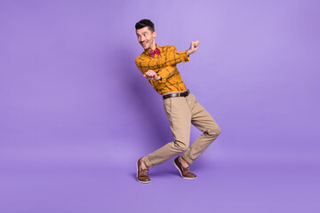 Fototapeta na wymiar Full size photo of young excited man happy positive smile dance look empty space isolated over purple color background