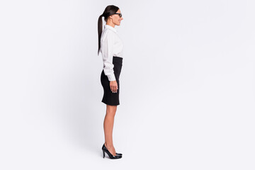 Fototapeta premium Full size profile photo of optimistic brunette hairdo lady near empty space wear spectacles shirt skirt isolated on grey background