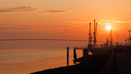 Fototapeta na wymiar Lever de soleil doré avec le port d'Honfleur et le pont de Normandie à contre jour