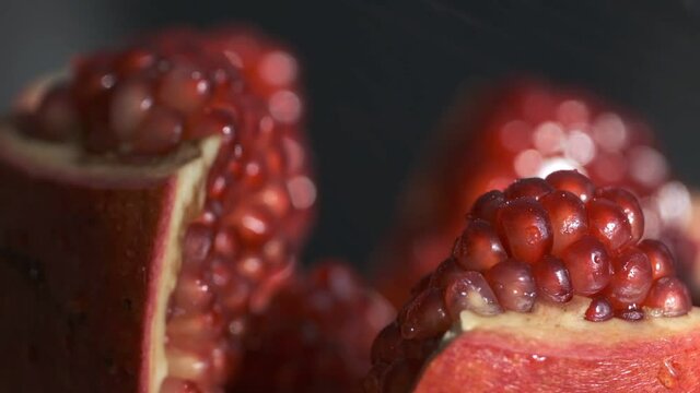 Pomegranate fruit. Slow motion shot. Fresh and ripe Pomegranates rotating over black Background. Organic Bio fruits close-up. Diet, dieting concept. Vegan foo