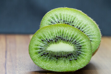sliced kiwi close-up on wooden table black background