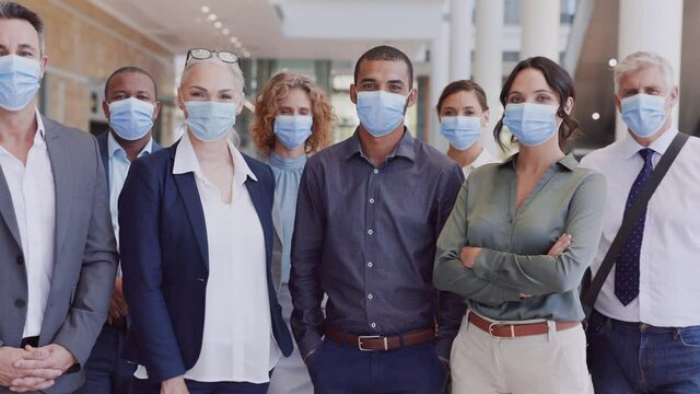 Proud business team wearing face mask at modern office during covid pandemic