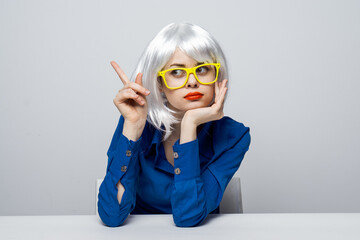 woman in yellow glasses holds hands on face emotions red lips 