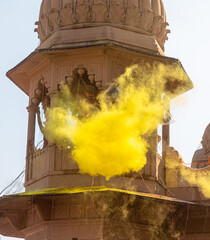 people celebrating holi festival by playing with colors at mathura, india.