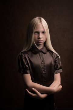 Classic studio portrait of a blonde girl wearing brown vintage silk dress