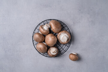 Obraz premium Royal mushrooms lie in a basket, which lies on a gray background.
