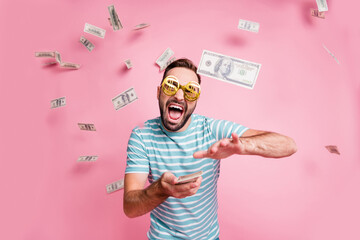 Portrait of nice cheerful guy wear dollar specs throwing budget spending wasting credit funds isolated over pink pastel color background