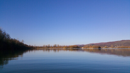 reed and rush reflected in the luster of the water at the edge of the lake. Phragmites australis plants during autumn season