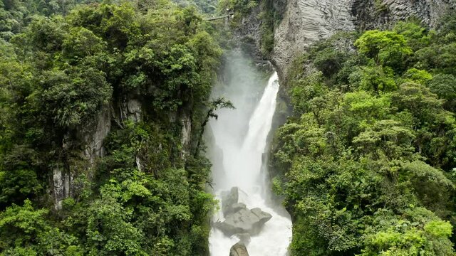 Aerial Back: Magnificent Cascade Pours From On Top Of Towering Cliffs Covered In Jungle Foliage