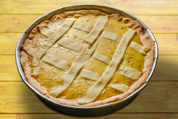 Easter cake, called napolitan pastiera, traditional homemade dessert in baking tray on rustic wooden table