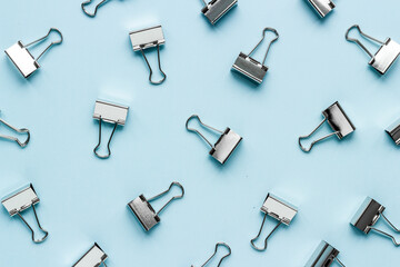 Flat lay of paper binder clips, office supplies pattern