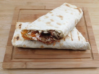 The process of cooking chicken wrap on kitchen table at home concept. Homemade kebab close up.