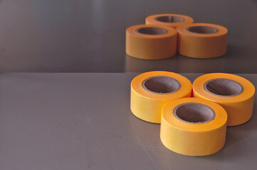 グレーのデスクに於かれた三つの黄色いテープ。