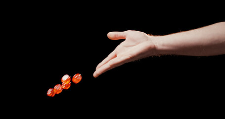 Close up of male hand throwing red dice with black background