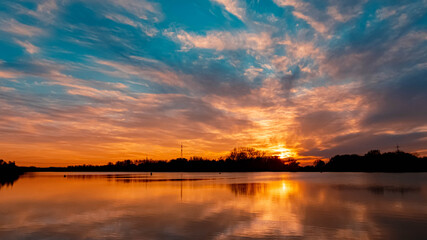 Obraz premium Beautiful autumn or indian summer sunset with reflections near Plattling, Isar, Bavaria, Germany