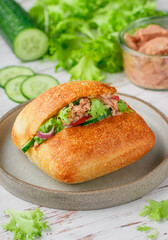 Delicious homemade sandwich with tuna, radish, cucumber, red onion and lettuce salad on a ciabatta bun. Healthy breakfast, lunch or dinner for gourmets. Mediterranean cuisine. Selective Focus