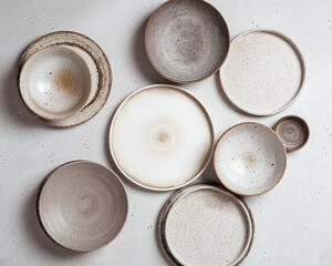 handmade ceramics, empty craft ceramic plates on light background top view - obrazy, fototapety, plakaty