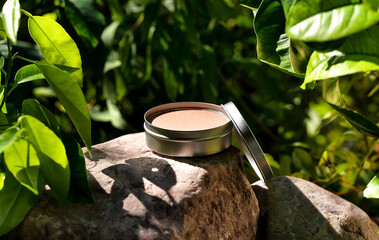 Cosmetic display on green leaves and natural stone backdrop. Natural cosmetics and beauty concept....