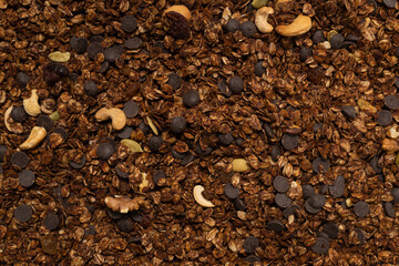 Chocolate granola cereal with nuts background.