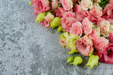 pink eustoma and rose flowers on stone surface