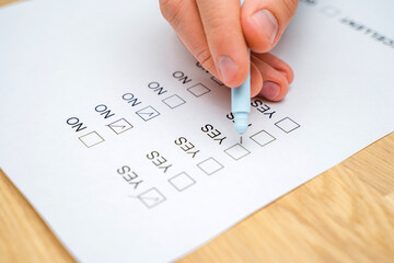 A questionnaire with answer options for the feedback form. A man ticks a box on a white paper while...