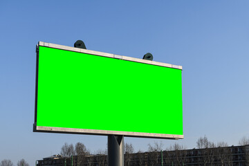 Blank green advertisement billboard in the city on a sunny day.