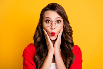 Photo of cute lady palms cheeks amazed look camera wear red blazer spectacles isolated yellow color background