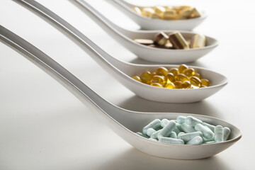 Four spoons filled of supplements diffrent color and shape. As a concept of natural medicines....