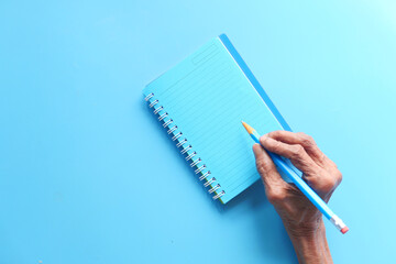 Close up of senior women hand writing on notepad.