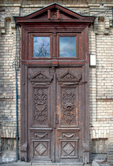 Old weathered beautiful doors. Wood carving. Wooden texture. Figure cutting on wood. Interior Retro Background. Traditional carved wooden doorway.