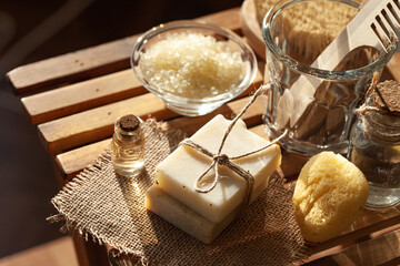 Zero waste and sustainable lifestyle concept. Eco-friendly bathroom accessories. Handmade soap, organic essential oil, sea salt, wooden background. Home body and face care. Contrast light, close-up