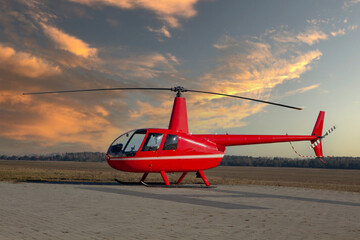 RED Helicopter Robinson R44 raven II - sunset at take-off site. - obrazy, fototapety, plakaty