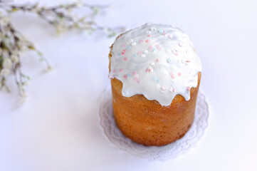 Easter cake, kulich with glaze on white wooden background
