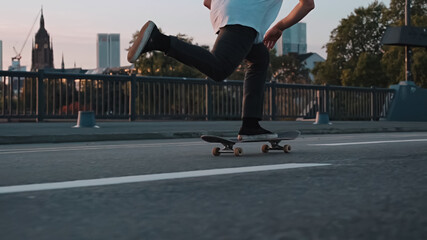 skateboarder pushing on bridge in front frankfurt skyline skyscrapers sunset