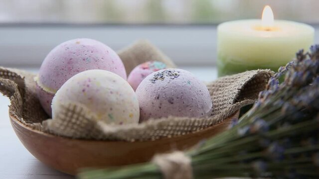 Selective focus on bath bombs and candle burning on background. Wellness and spa concept.