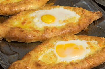 Street food in Ukraine -  Georgian khachapuri as traditional Adjarian version  bread  filled with cheese, butter and egg yolk in the middle