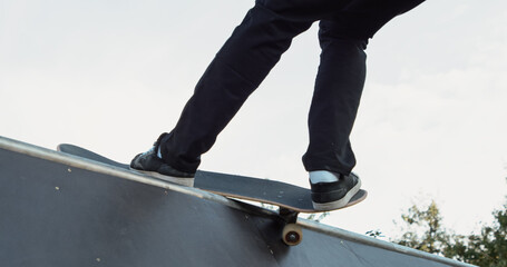 Fototapeta na wymiar Young male adult skateboarding halfpipe miniramp grinding and makes tricks