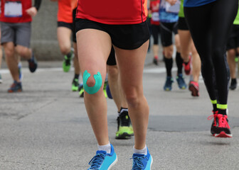 Fototapeta na wymiar runner during the foot race with the knee bandage to avoid muscl