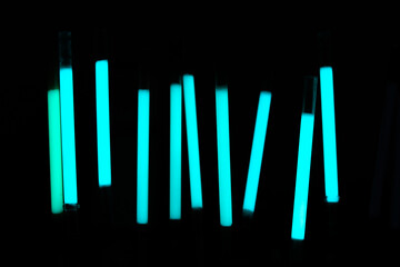 Demonstration of the work of fluorescent sticks in the dark. Bright blue on a dark background