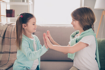 Photo portrait of small children clapping hands playing game careless sitting in room at home