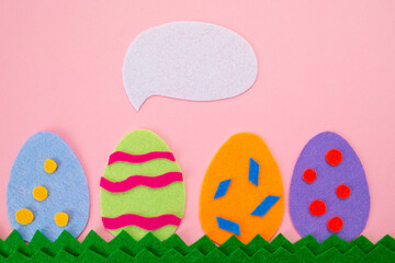 Fototapeta na wymiar Easter. Cut out the felt applications of four colorful eggs on pink background. Copy space. Flat lay
