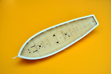 Making a model of a sailing ship, the hull of the ship on a yellow background.