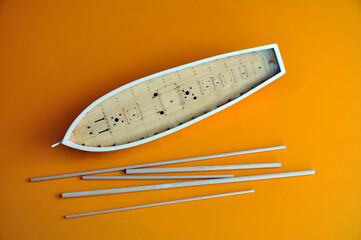 Making a model of a sailing ship, the hull of the ship on a yellow background.