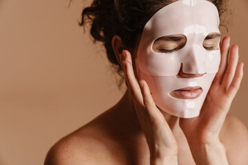 Half-naked european woman posing in cosmetic facial mask